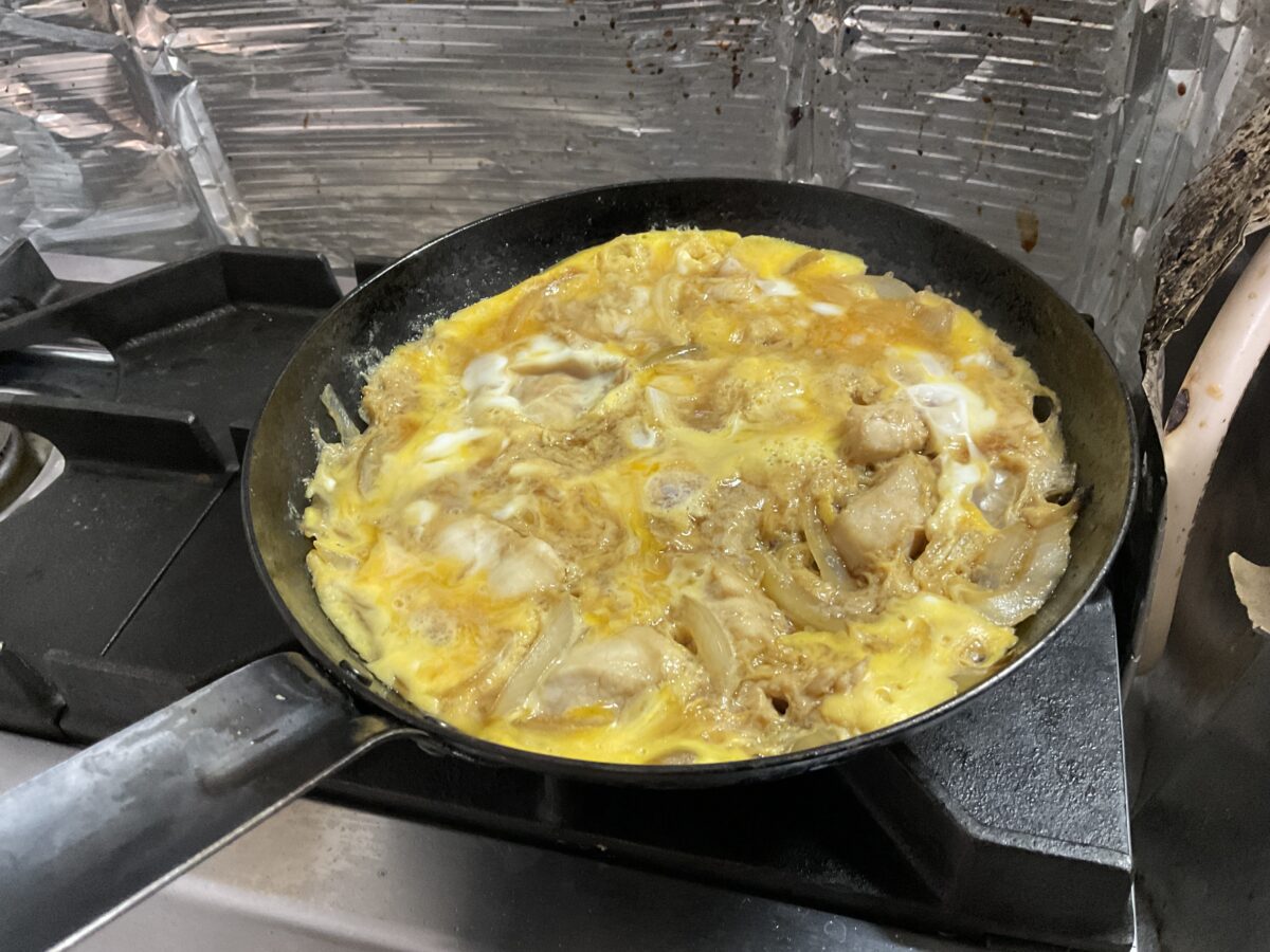 遠藤商事の20cm鉄フライパンで親子丼の鶏肉と玉ねぎ、卵を調理している様子