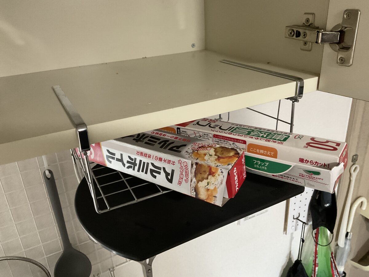 吊戸棚下のワイヤーラックにラップやアルミホイルを収納している一人暮らしのキッチン