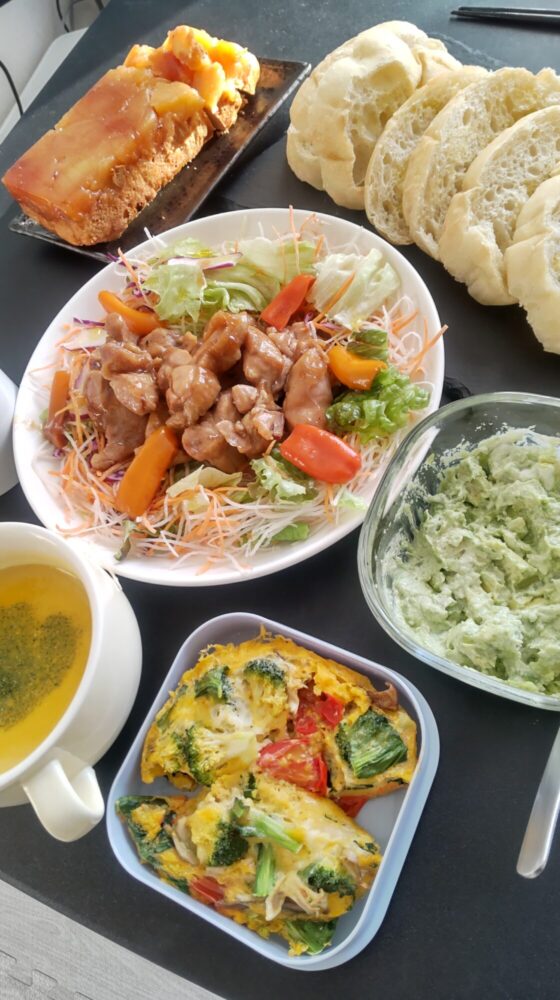 チキンサラダを中心にバゲットやオムレツを並べたショウの手作りランチ