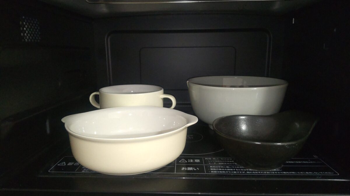 東芝オーブンレンジER-YD70-Kの庫内に複数の食器を並べて汁物を含む料理を温める様子