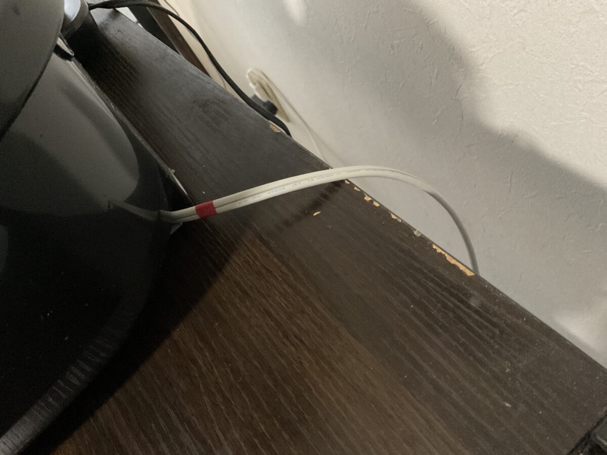 調理家電ラックの棚板に炊飯器の電源コードが擦れて表面が剥げた様子
