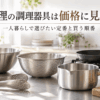 柳宗理の調理器具選びをイメージした、ステンレスボウル・ストレーナー・トング・鍋・フライパンを並べたキッチン