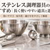 ステンレス製のボウル、ザル、トング、泡立て器、お玉、キッチンバサミを並べた調理器具