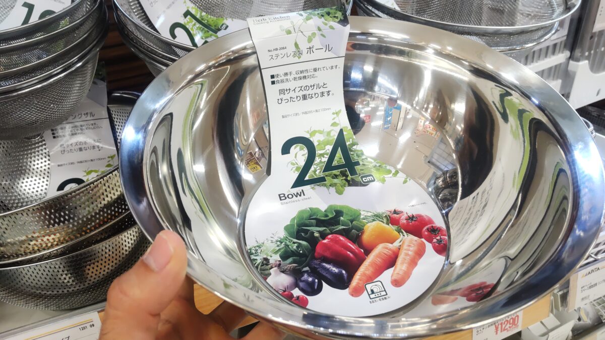 24cmのステンレス製ボウルを売り場で手に持ってサイズ感を確認している様子