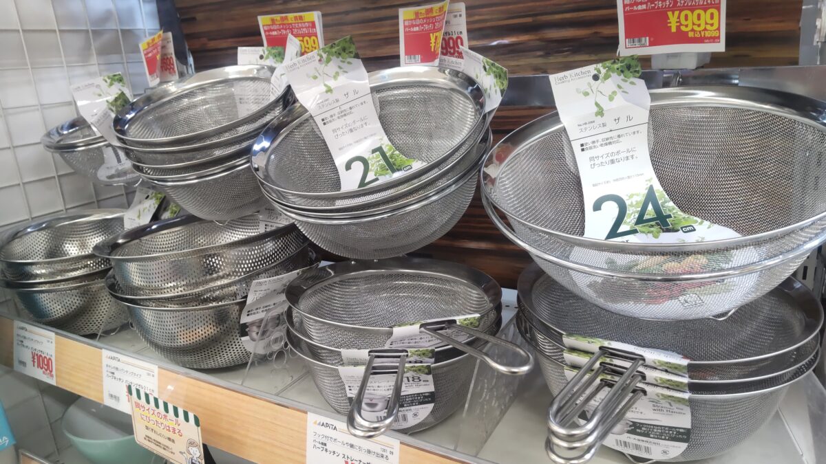 21cmや24cmなどサイズ違いのステンレス製ザルがキッチン用品売り場に並んでいる様子
