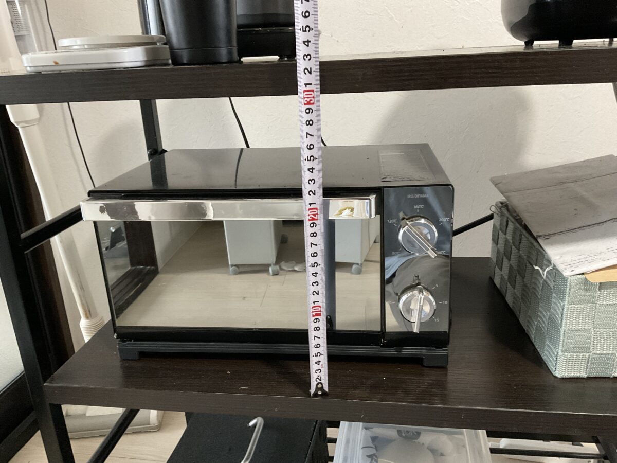 オーブントースターを置いたラックの棚までの高さをメジャーで測っている様子