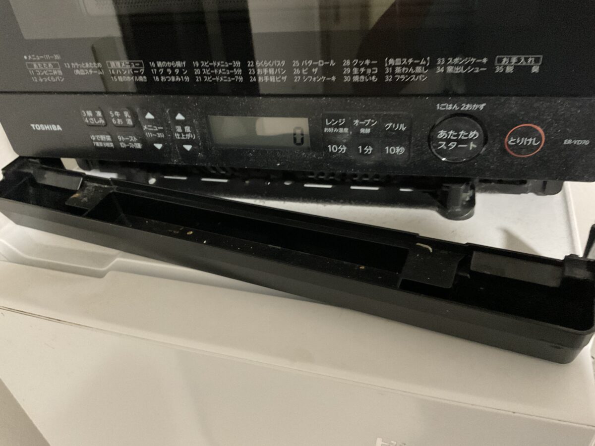東芝ER-YD70-Kオーブンレンジの本体下部トレーを引き出して汚れを確認している様子